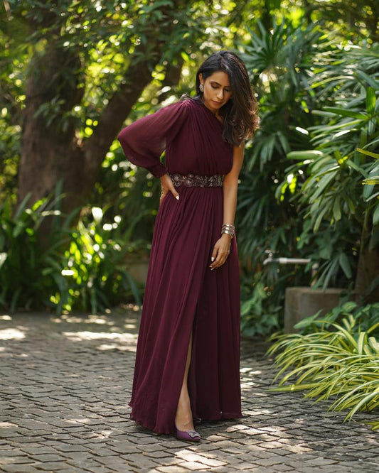 Burgundy one shoulder slit gown with belt.